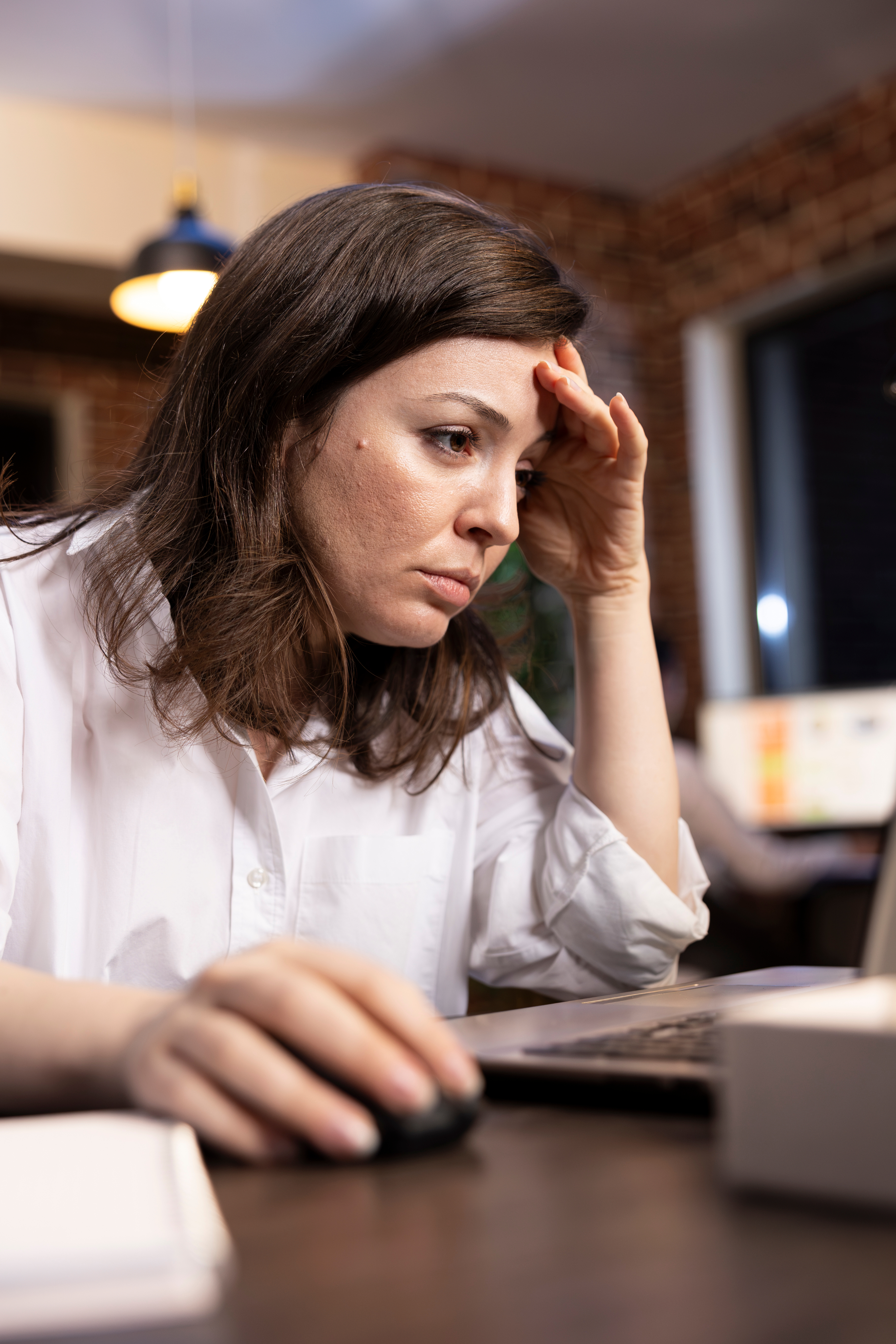 Woman worried while reviewing finances on a laptop